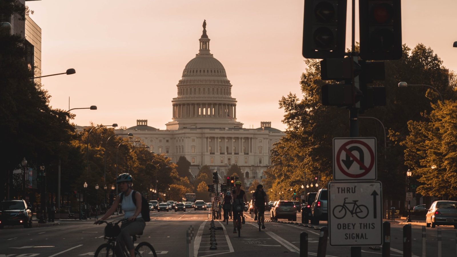 The US Capitol building, where the Senate passed the Inflation Reduction Act, in the background with people riding bicycles in the foreground.